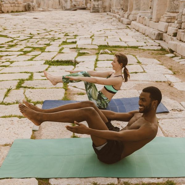 Diverse group of people smiling during a calm yoga session outdoors.