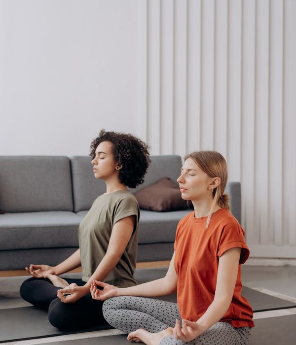 Woman holding a serene yoga pose in a bright, minimalist room.